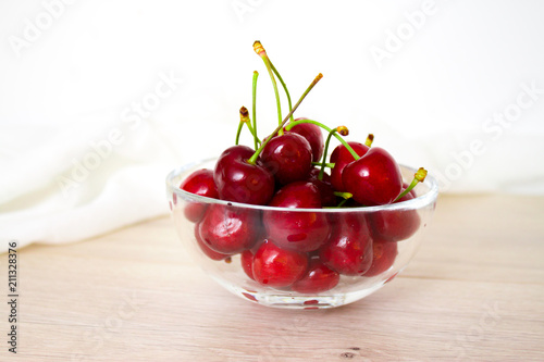 Cherries in glass dish. Cherry on wood and white background. - healthy eating and food concept photo