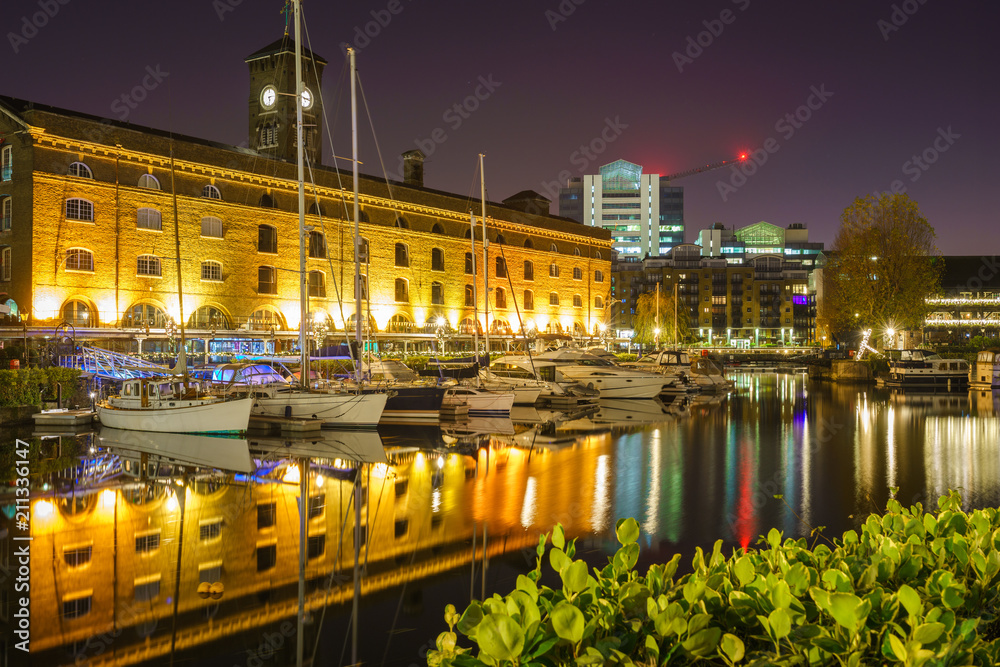 St Katharine dock in London at night, UK. Modern yacht and boat pier near Tower Bridge with view of Ivory House