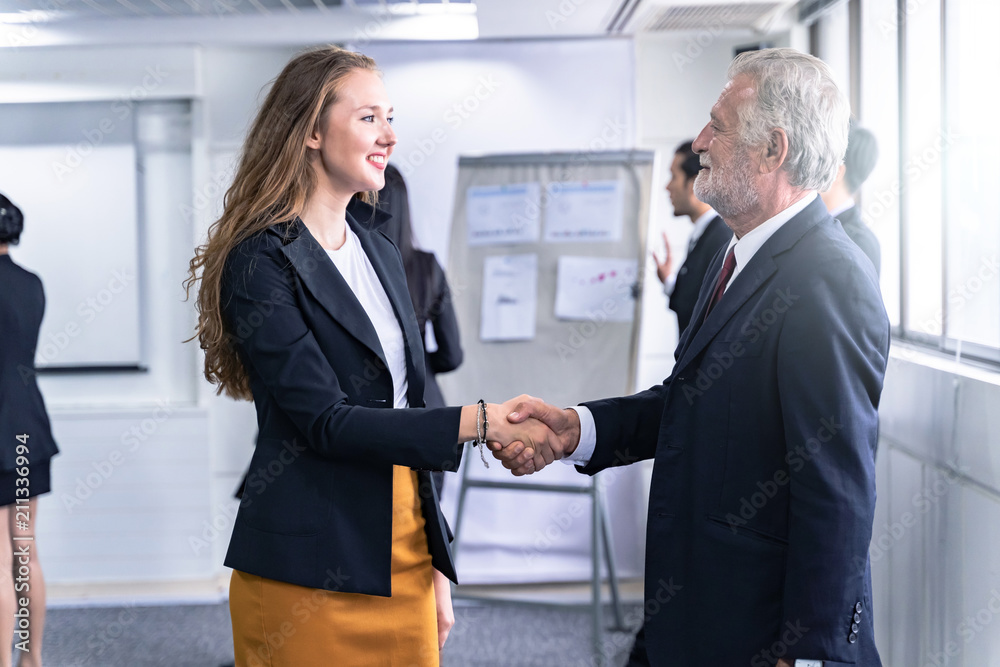Business man and Business Woman shaking hands and discussion with colleague in meeting room or conference room and audience.