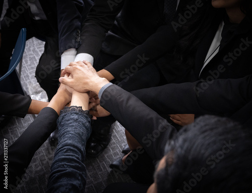 Close up top view of business people putting their hands together. Stack of hands. Unity and teamwork Partnership and togetherness concept. © nattanan