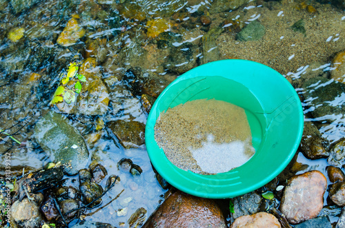 Фотография Gold pan filled with mineral rich material ready to pan for gold and gemstones