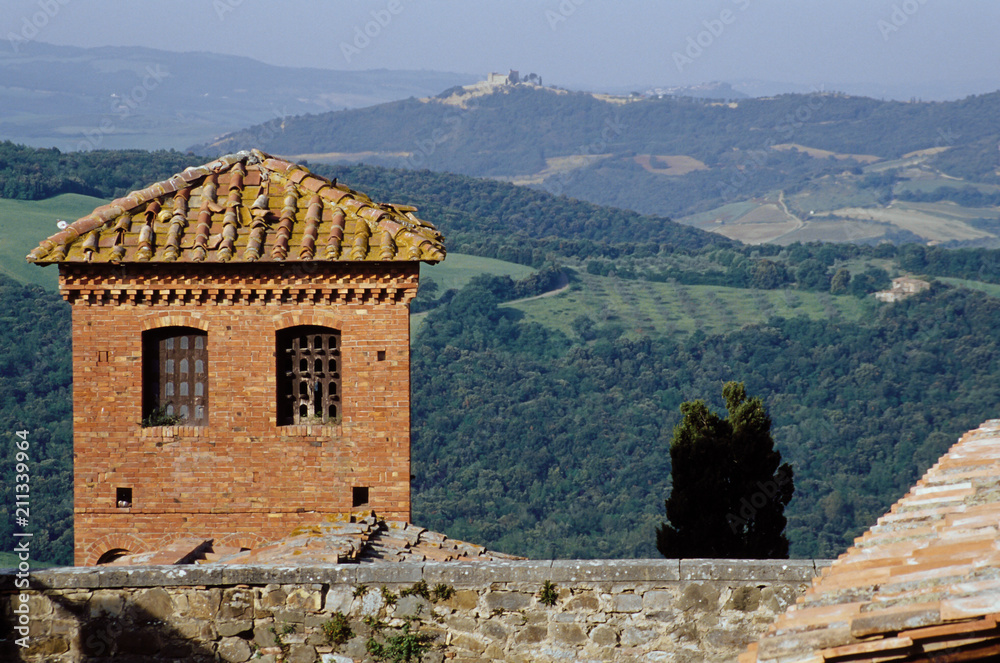 View from the Ripa d'Orcia of a brick tower, across the Tuscan countryside to another hilltop castle.