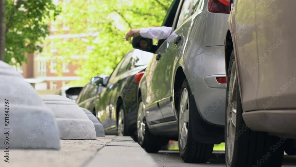 Man smoking in car, throwing stub of cigarette on pavement, bad manners, ecology