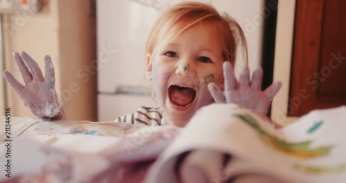Frustrated child dirty with paints having a tantrum photo