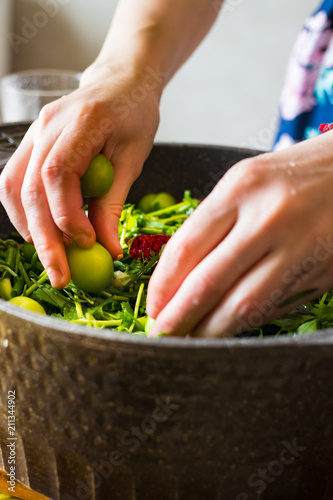 Preparation or cooking of chakapuli in cauldron pan. Ingredients: lamb meat, green tkemali sour plum, onion sprouts, cilantro, tarragon leaves. Georgian traditional stew photo