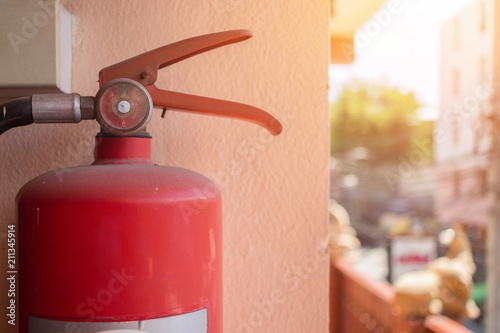 Red Fire extinguisher on the wall that is installed in various building for when there is a fire.