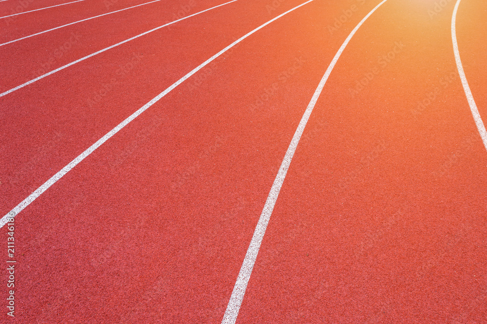 White lines of stadium and texture of running racetrack red rubber racetracks in outdoor stadium are 8 track and green grass field,empty athletics stadium with track.