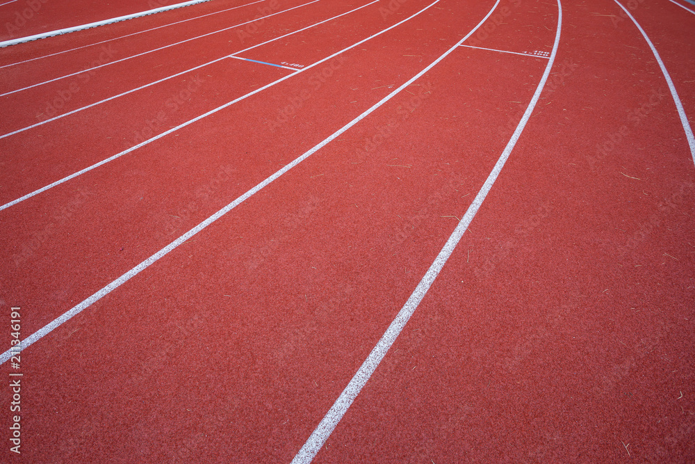 White lines of stadium and texture of running racetrack red rubber racetracks in outdoor stadium are 8 track and green grass field,empty athletics stadium with track.