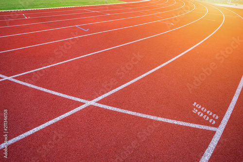 White lines of stadium and texture of running racetrack red rubber racetracks in outdoor stadium are 8 track and green grass field empty athletics stadium with track.