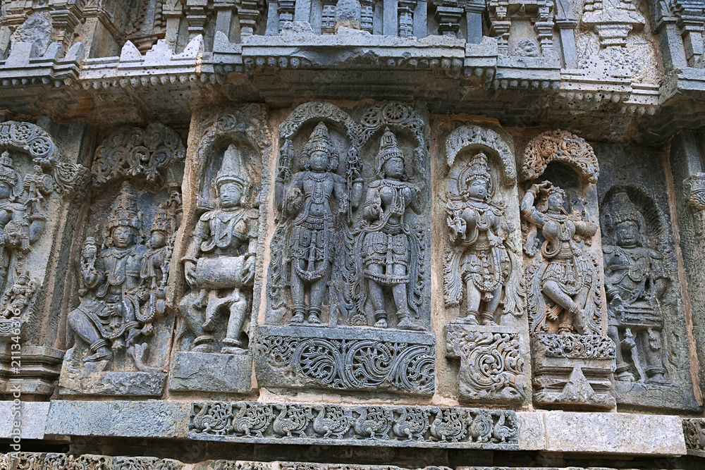 Ornate wall panel reliefs depicting From left Shiva-Parvati, a drumer, Lakshmi-Narayana, and other deities Kedareshwara temple, Halebidu, Karnataka