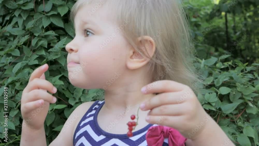 Little cute girl eating red currant Little cute girl eating red currant