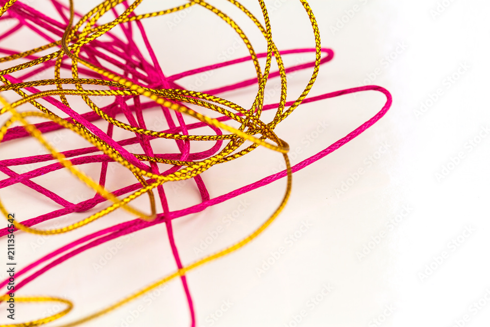 disorganized pile of pink and gold rope on white background disorganized pile of pink and gold rope on white background