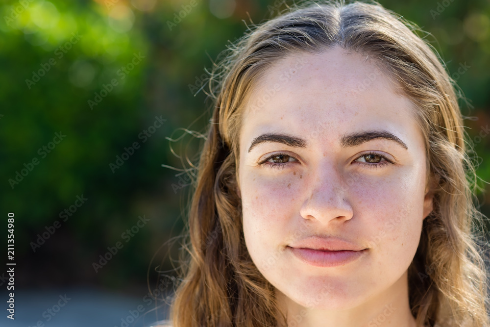 Close-up of a young woman outdoors in yard in summer afternoon Close-up of a young woman outdoors in yard in summer afternoon