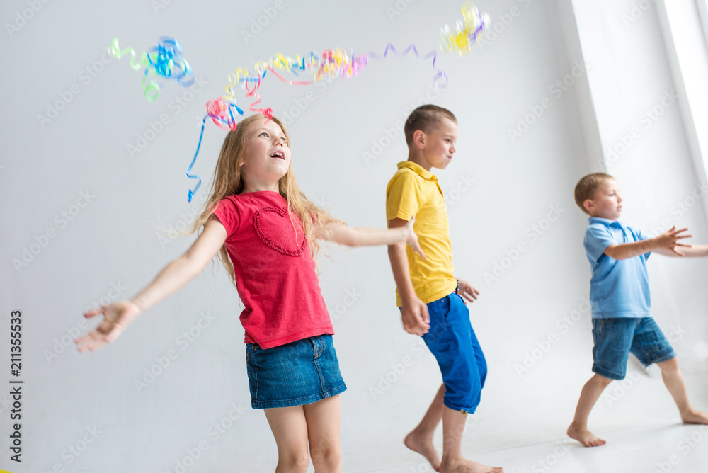 Three happy children plays with air balloons and confetti on birthday party Three happy children plays with air balloons and confetti on birthday party