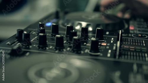 DJ tweak track controls on DJ control panel.