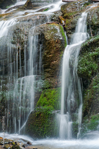 close up of waterfall cascade over the mossy rock. beautiful calm nature background. freshness and power of water. clear environment and resources concept