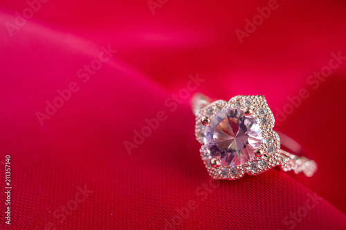 Jewelry luxury pink gold ring with sapphire gemstone on red fabric texture background