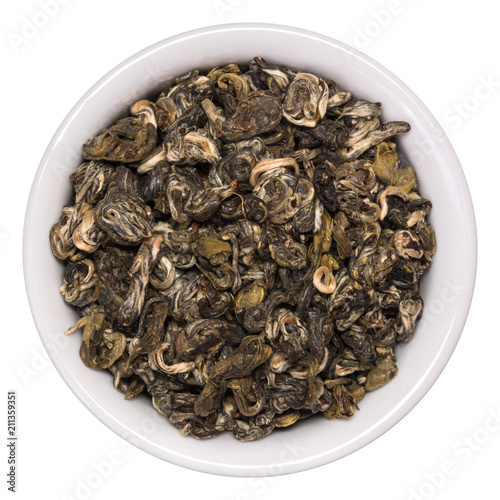 Pile of dry green tea Bilochun snail in white bowl isolated on white background. Top view from above