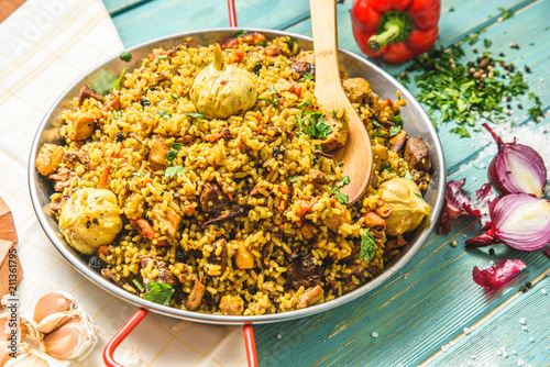 Pilaf with chicken.Chicken,rice,onion,carrots,vegetable oil.Ready pilaf mix,lay on the lagans,spread on top of rice chicken.Uzbek national dish. photo