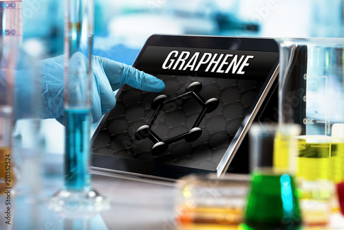 engineer working in the research laboratory with the tablet and symbol graphene in the screen / researcher working in the lab with screen computer and conceptual representation of graphene material 
