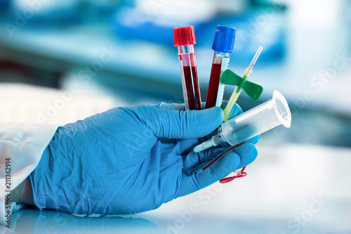 lab technician hand holding blood collection tubes and catheter with tube holder / laboratory technician tools for taking blood sample