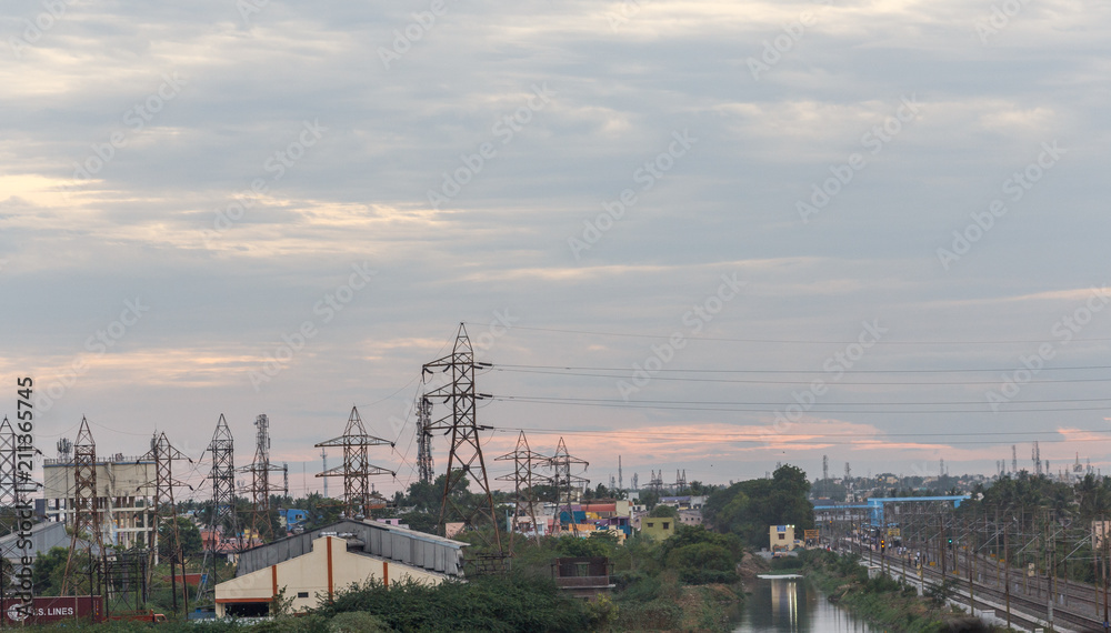 Electricity power substation in chennai india, where electrical power is generated, transmitted, and distributed to systems. Photographed during sunset with low lighting conditions, dark clouds in sky