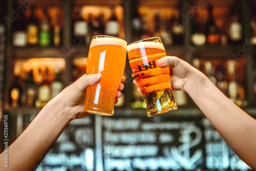 Two friends toasting with glasses of light beer at the pub Fototapeta