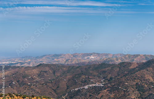 beautiful view of the mountains in the region of Andalusia, houses and farmland on the slopes of mountains