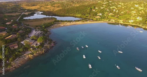 Aerial, beautiful bay with some anchored boats and yachts and crystalline water on sunrise