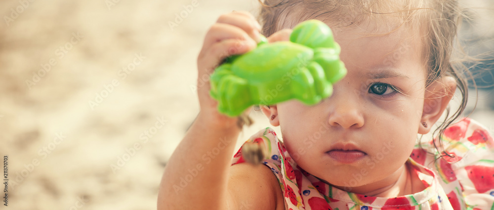 Cute little girl portrait holding and looking at sand toy, letterbox Cute little girl portrait holding and looking at sand toy, letterbox