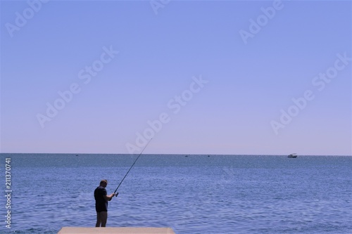 рыбак с удочкой на море © andros1983