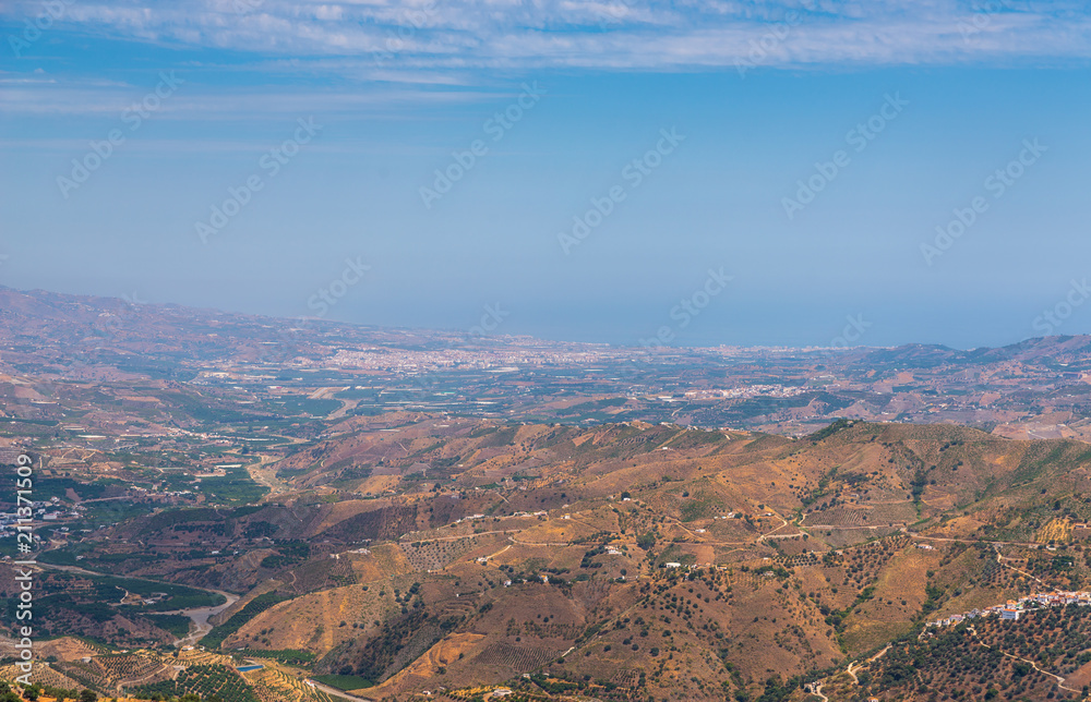 beautiful view of the mountains in the region of Andalusia, houses and farmland on the slopes of mountains