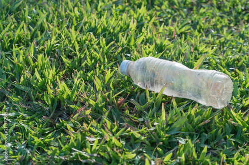 Plastic bottle garbage on green grass at park for environment protection © StockGood
