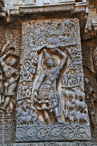 Sculpture of lord Krishna as Govardhan Girdhari, west side wall, Hoysaleshwara temple, Halebidu, Karnataka.