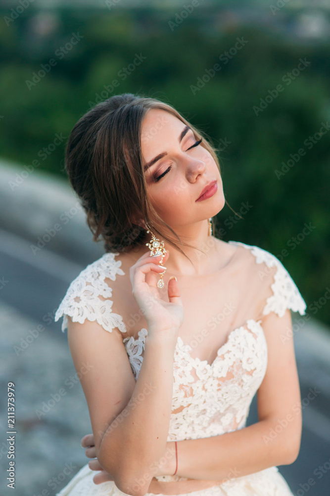 Teenage girl in wedding dress on city. Background town sunset Teenage girl in wedding dress on city. Background town sunset