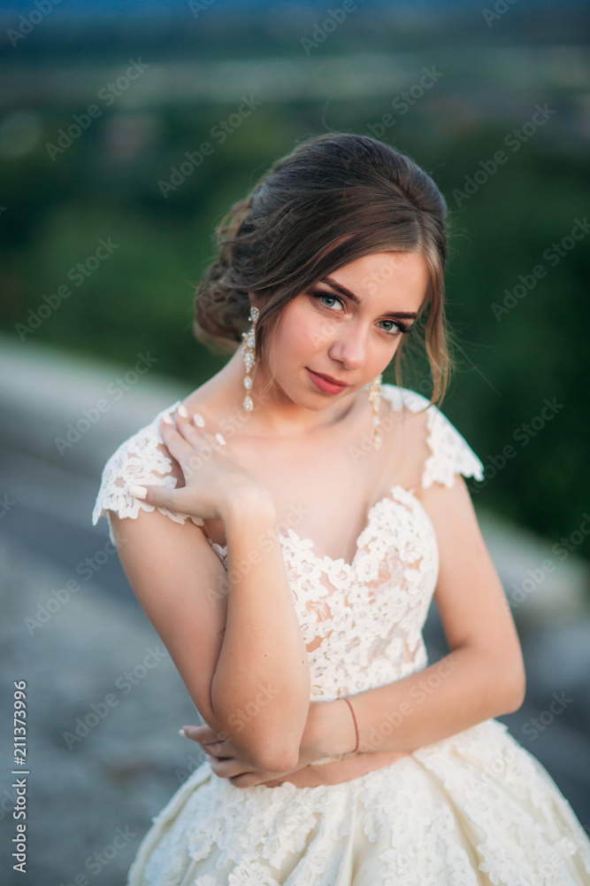 Teenage girl in wedding dress on city. Background town sunset Teenage girl in wedding dress on city. Background town sunset