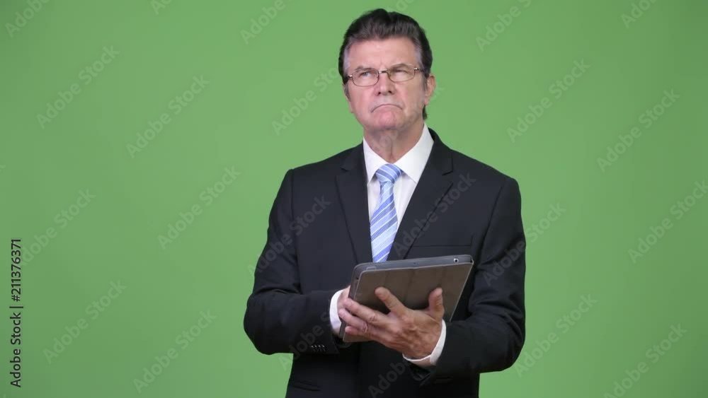 Senior handsome businessman using digital tablet Senior handsome businessman using digital tablet