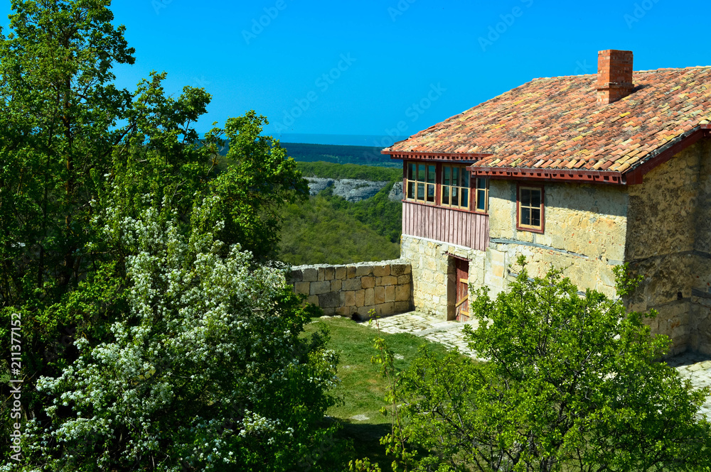 Old stone house with a tiled roof high in the mountains surround the green trees. Old stone house with a tiled roof high in the mountains surround the green trees.