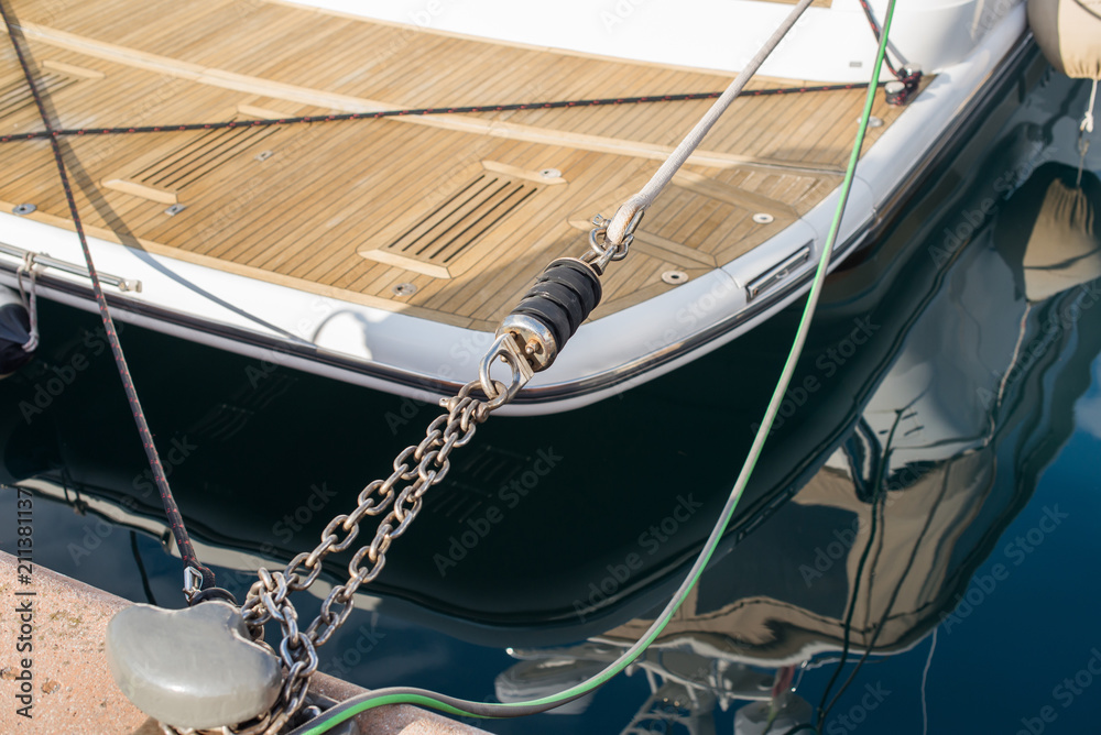 Parking the yacht to the pier with mooring spring and chain