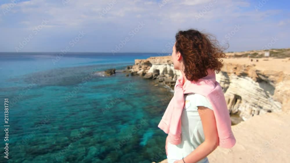 Tranquil woman enjoy rocky sea landscape. Tourist woman relaxing on sea shore at summer vacation. Thoughtful woman on rocky cliff at holiday trip. Alone woman looking on rocky water landscape Tranquil woman enjoy rocky sea landscape. Tourist woman relaxing on sea shore at summer vacation. Thoughtful woman on rocky cliff at holiday trip. Alone woman looking on rocky water landscape