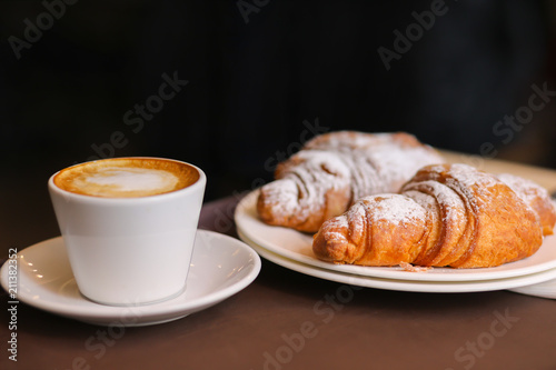 Cappuccino with hot croissant in cafe