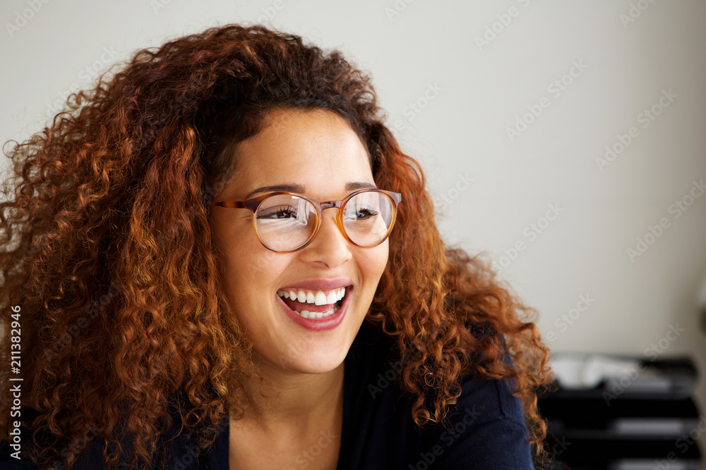 young woman with glasses laughing and looking away young woman with glasses laughing and looking away