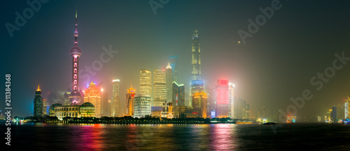 Photography Chinese Shanghai Skyline glowing in a misty night, reflecting in waters of Huang