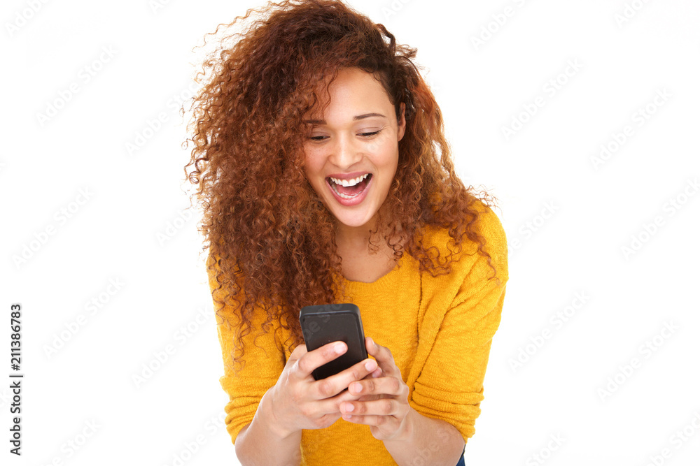 Close up cheerful young woman laughing with mobile phone against isolated white background Close up cheerful young woman laughing with mobile phone against isolated white background