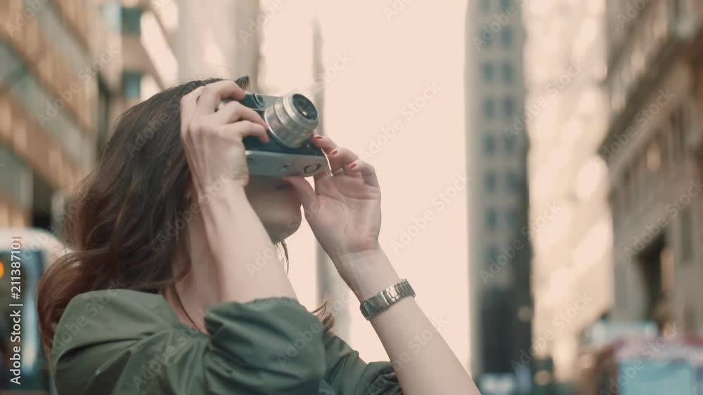 Young girl doing a photo of a skyscraper in the street Young girl doing a photo of a skyscraper in the street