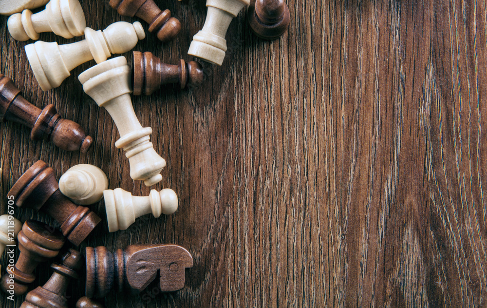 scattered chess pieces on a wooden background scattered chess pieces on a wooden background