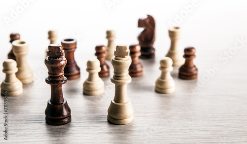 wooden chess pieces on a grey background and black and white chess kings