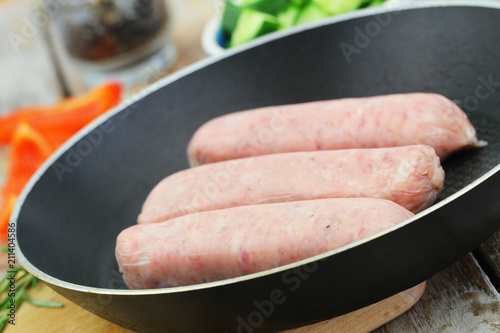 Uncooked British pork sausages in frying pan
