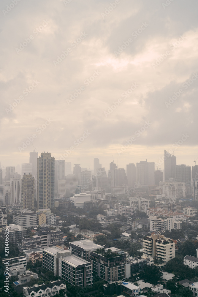 Rain over Bangkok: Cityscape behind the window glass with rain drops.