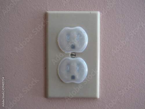 An American outlet with safety childproof outlet covers on them 